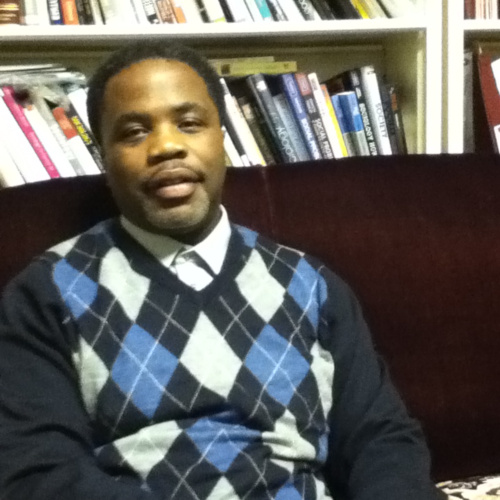 Portrait of Dr. Aaron C. Porter, an African American man, seated, wearing an argyle sweater